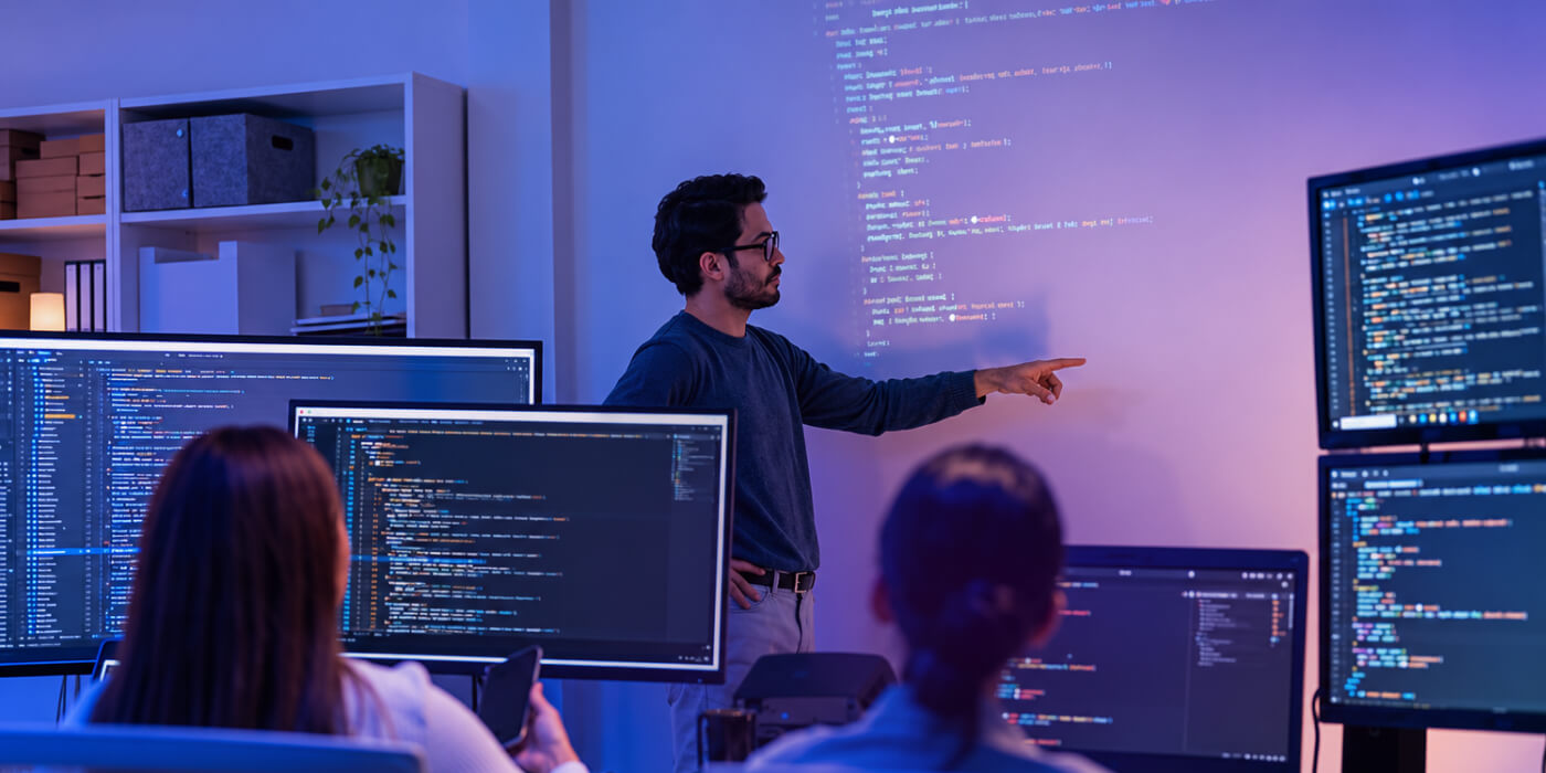 Team reviewing AI automation workflows on multiple monitors in a modern office